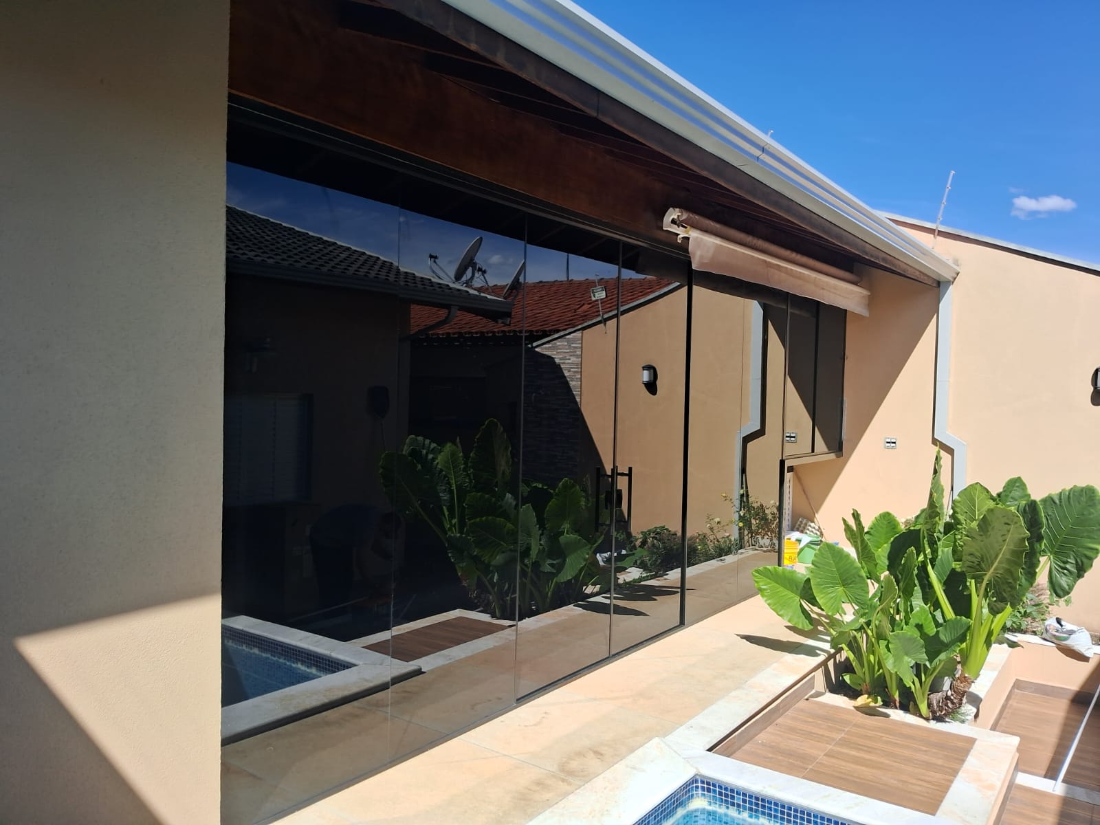 Envidraçamento de sacada com vidro fumê e vista para piscina em Valinhos