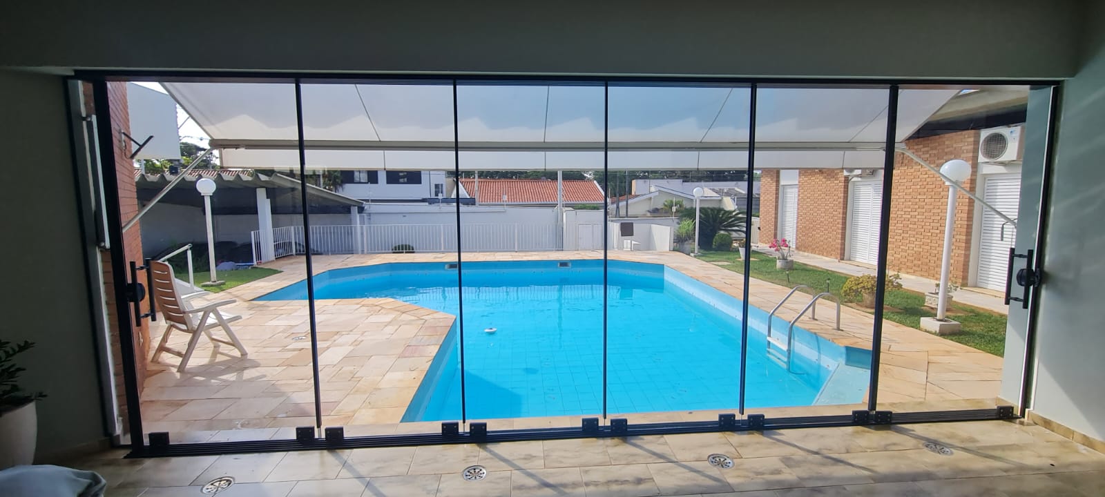 Sacada de vidro retrátil em Campinas com vista para piscina
